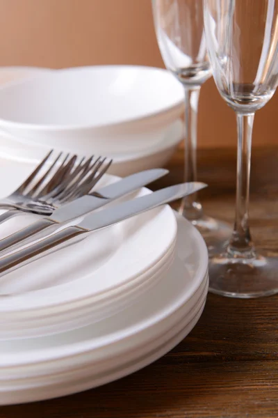 Set de platos blancos sobre mesa sobre fondo marrón — Foto de Stock