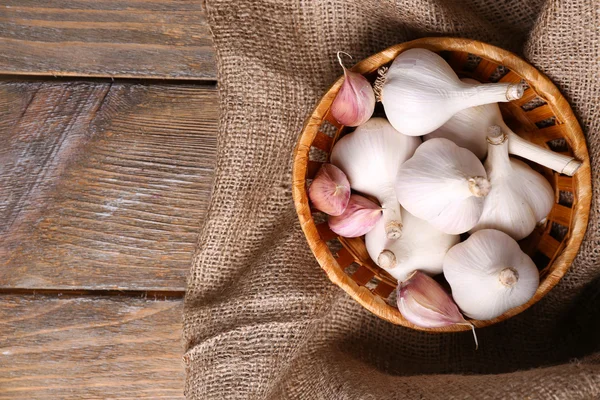 Ail frais dans un panier en osier, sur fond de bois — Photo