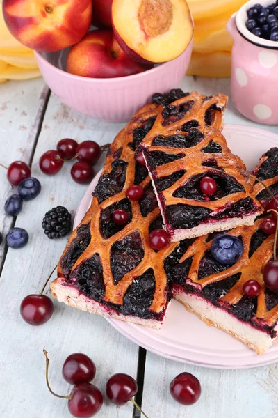 Sweet berries and berry tart on table close-up