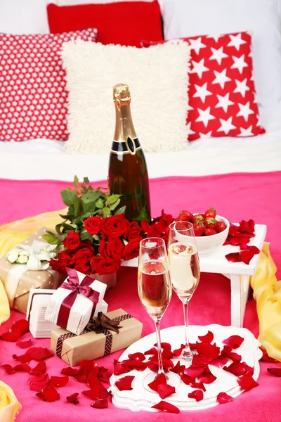 Natura morta romantica con champagne, fragole e rose sul letto — Foto Stock