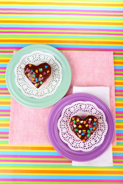 Deliciosos mini pasteles de arco iris en servilleta de papel, sobre un fondo brillante — Foto de Stock