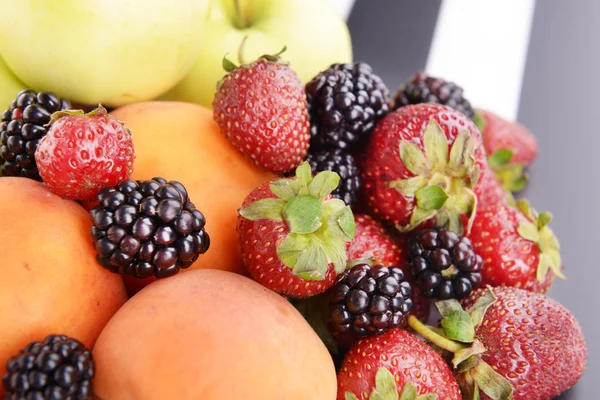 Frutas maduras y bayas sobre fondo rayado — Foto de Stock