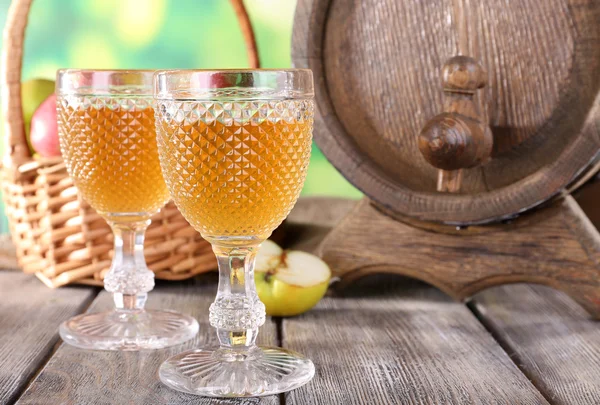 Still life with tasty apple cider and fresh apples, on nature background — Stock Photo, Image