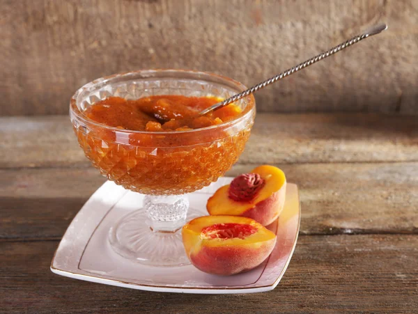 Tasty apricot jam with fresh apricots on wooden table — Stock Photo, Image