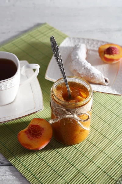 Light breakfast with cup of tea and homemade jam on wooden table — Stock Photo, Image