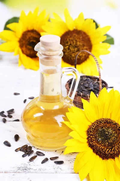 Sunflowers with seeds and oil on table close-up — Stock Photo, Image