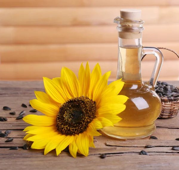 Sonnenblume mit Kernen und Öl auf Holzgrund — Stockfoto