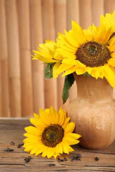 Hermoso ramo de girasoles en jarra sobre mesa sobre fondo de madera —  Fotos de Stock