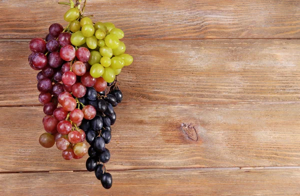 Bunches of grapes on wooden background — Stock Photo, Image