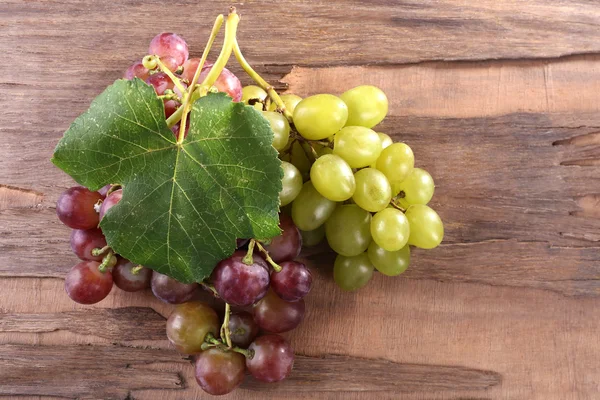 Bunches de diferentes tipos de uvas em fundo de madeira — Fotografia de Stock