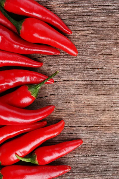 Pimientos rojos picantes sobre fondo de madera — Foto de Stock