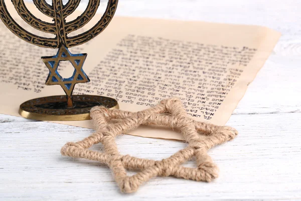 Menorah, star of David and page of Genesis book on wooden background — Stock Photo, Image