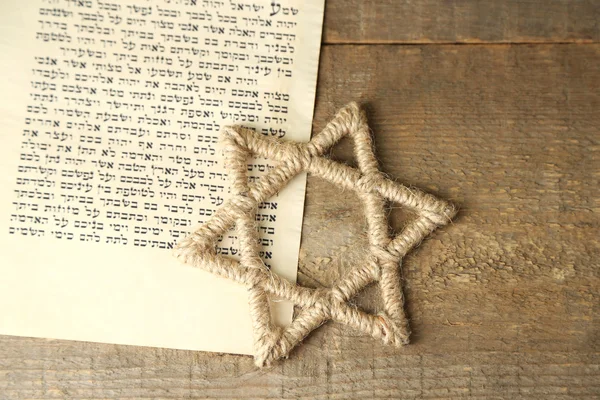 Star of David and page of Genesis book on wooden background — Stock Photo, Image