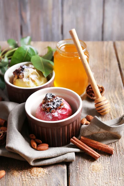 Baked apples in bowls on table on wooden background — Stock Photo, Image