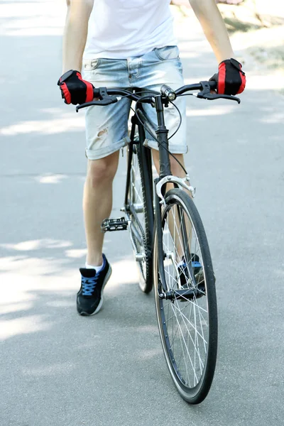Jeune homme à vélo dans le parc de la ville — Photo