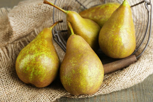 Ripe pears in basket on wooden background — Stock Photo, Image