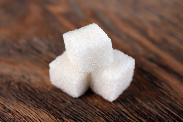 Açúcar refinado branco sobre fundo de madeira — Fotografia de Stock