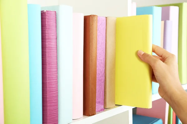 Hand picking book in library — Stock Photo, Image