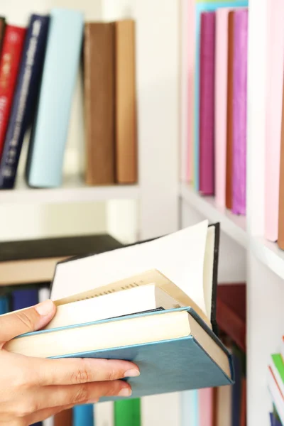 Hand picking book in library — Stock Photo, Image