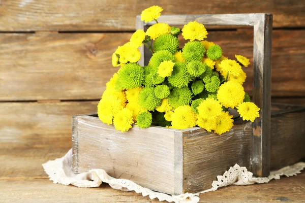 Sárga és zöld virág kosár, fából készült háttér — Stock Fotó