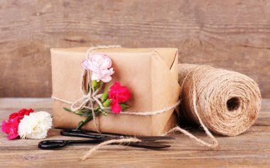 güzel hediye çiçek ve eski ahşap zemin üzerinde dekoratif ip ile