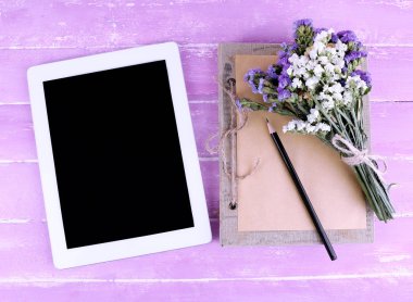 Tablet, defter, kalem ve alan çiçek ahşap zemin üzerinde grup