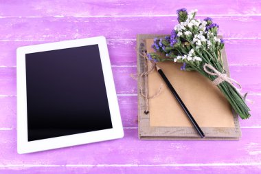 Tablet, defter, kalem ve alan çiçek ahşap zemin üzerinde grup