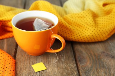 Cup of tea with tea bag on wooden table close-up