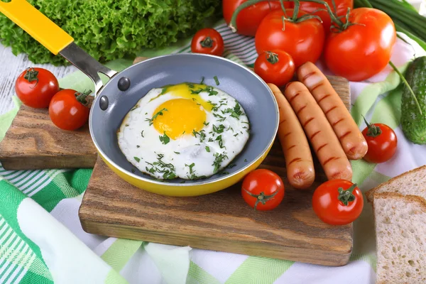 Scrambled egg with sausage and vegetables served on pan on cutting board — Stock Photo, Image