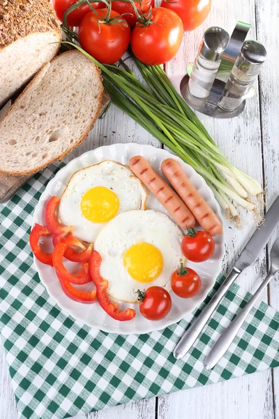 Scrambled eggs with sausage and vegetables served on plate on napkin — Stock Photo, Image