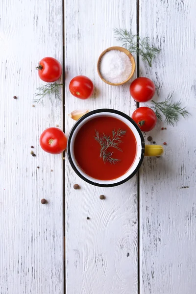Sumo de tomate caseiro na caneca a cores, especiarias e tomates frescos no fundo de madeira — Fotografia de Stock