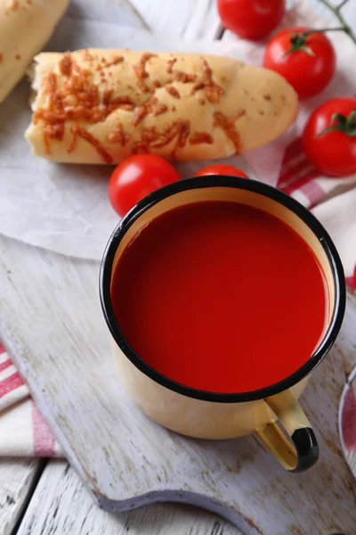 Homemade tomato juice in color mug, bread sticks, spices and fresh tomatoes on wooden background — Stock Photo, Image