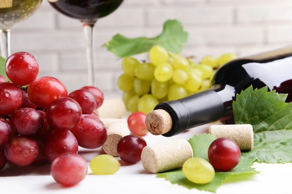 Rolhas de garrafa de vinho com uvas em close-up de mesa — Fotografia de Stock