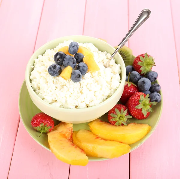 Cottage cheese with fruits and berries in bowl on wooden table — Stock Photo, Image