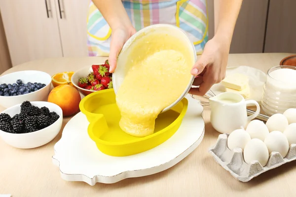 Hornear sabroso pastel e ingredientes para ello en la mesa en la cocina —  Fotos de Stock