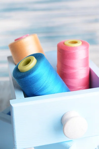 Sewing Accessories in wooden boxes on table on light blue background — Stock Photo, Image