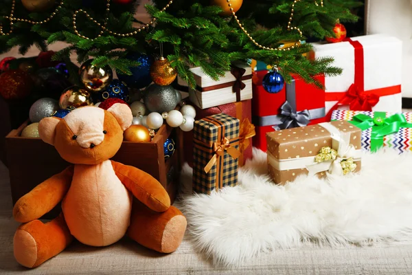 Много рождественских подарков на полу в праздничном интерьере — стоковое фото