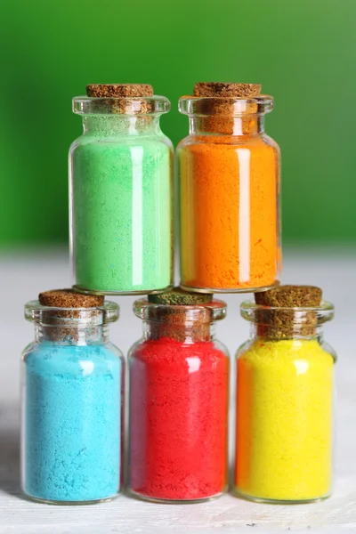 Bouteilles avec des pigments secs colorés sur fond lumineux — Photo