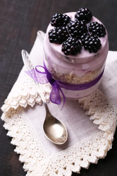 Gezond ontbijt - yoghurt met bramen en muesli geserveerd in glazen pot, op donkere houten achtergrond — Stockfoto