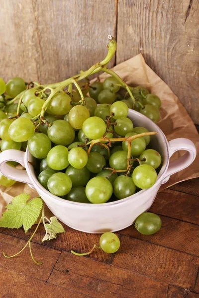 Green grapes in bowl on wooden background — Stock Photo, Image