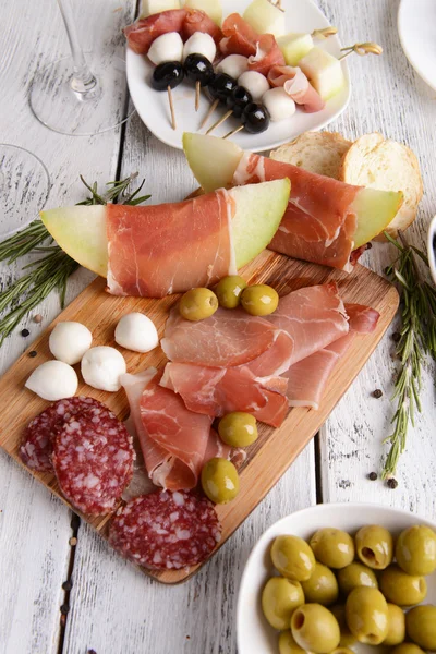 Delicious melon with prosciutto on table close-up — Stock Photo, Image