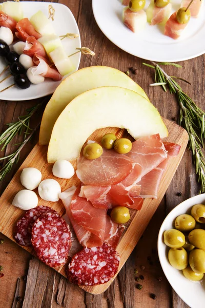 Delicious melon with prosciutto on table close-up — Stock Photo, Image