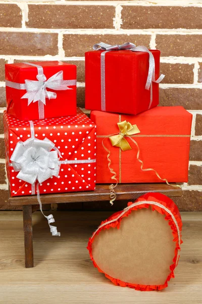 Regalos de Navidad en taburete sobre fondo de pared de ladrillo marrón — Foto de Stock