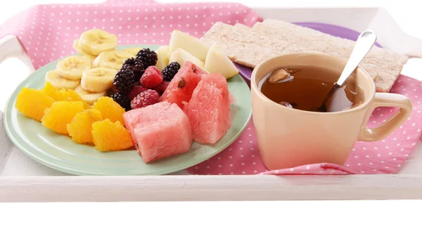 Rebanadas de frutas con pan crujiente en el plato y taza de té en bandeja de madera de cerca —  Fotos de Stock