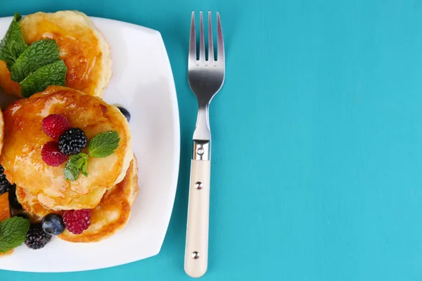 Tasty pancake with fresh berries and mint leaf on plate, on color wooden background — Stock Photo, Image