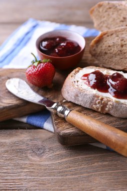 ahşap arka plan üzerinde ev yapımı tereyağı ve çilek reçel taze tost