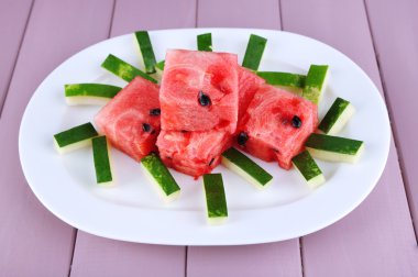 Ahşap arka plan üzerinde beyaz tabakta karpuz dilimleri