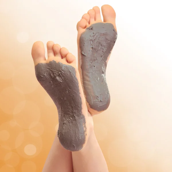 Woman foots with cosmetic clay on bright background — Stock Photo, Image