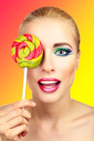 Hermosa mujer con piruleta de colores, sobre fondo brillante —  Fotos de Stock