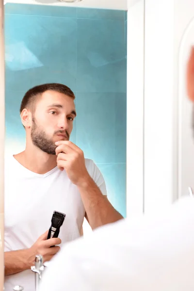 Jovem barbear sua barba no banheiro — Fotografia de Stock